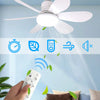 A hand holds a white remote control for an LED ceiling fan with remote control and dimming, illuminating a room.