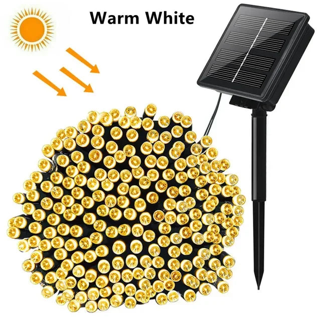 A cluster of warm white solar powered outdoor LED string lights with a black mounting pole.