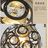 A close-up view of a crystal LED chandelier lamp featuring intricate glasswork and gold accents.
