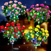 A display of vibrant pink, red, and yellow LED azalea flowers illuminated in a dark garden setting.