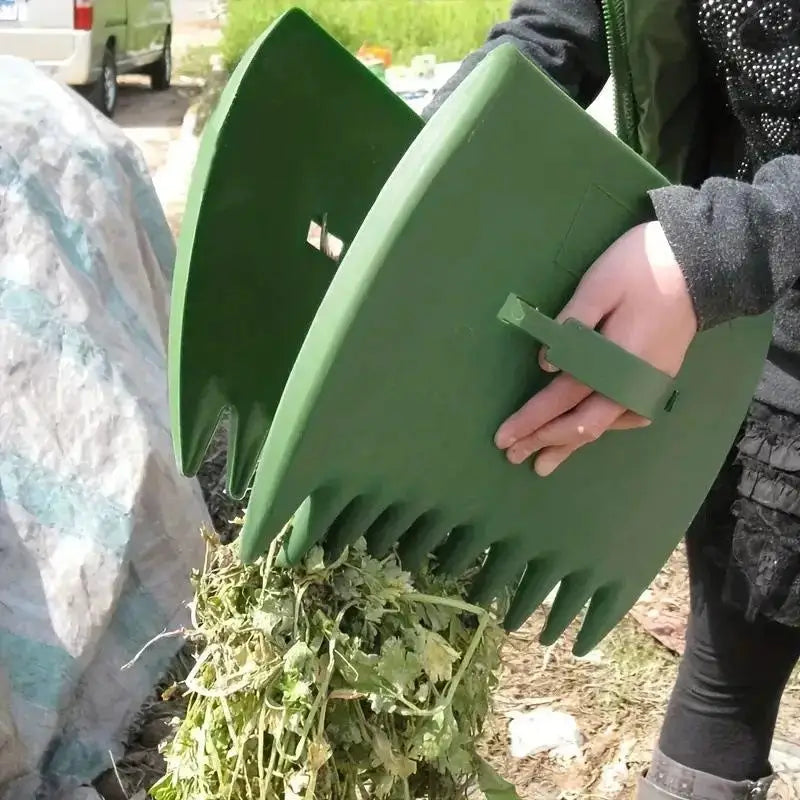 A hand holds a green plastic leaf grabber rake used for yard cleaning.