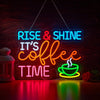 An illuminated neon sign spelling out RISE & SHINE IT'S COFFEE TIME on a dark wooden background.