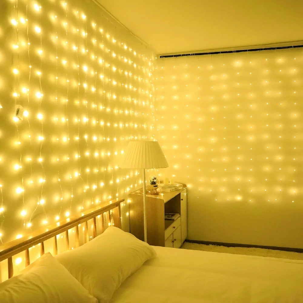 Un dormitorio con una cama iluminada por tiras verticales de luces de hadas amarillas cálidas en la pared.