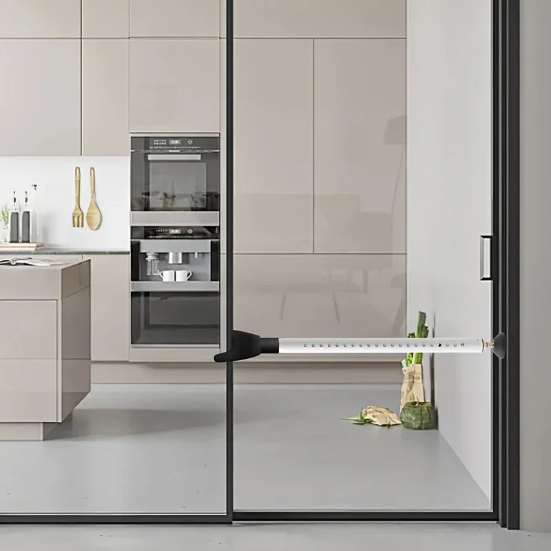 A close-up view of an adjustable portable door security bar mounted on a glass door frame.