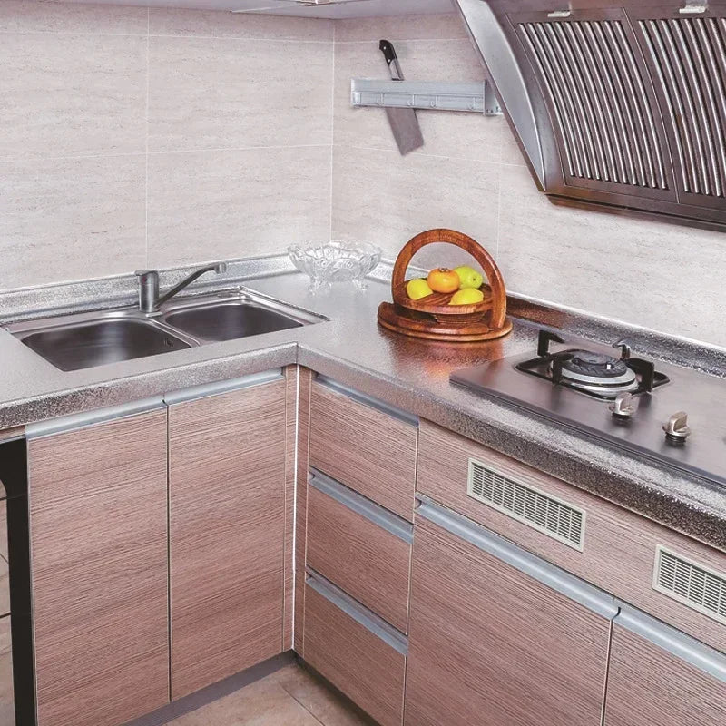 Plan de travail de cuisine avec évier en acier inoxydable et planche à découper avec des citrons jaunes.