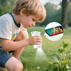 A young child is using a handheld microscope to explore plants outdoors.