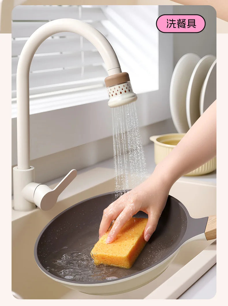 A hand is using an extendable tap filter sprayer to dispense water onto a frying pan.