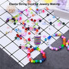 A collection of colorful elastic string cords and beads for jewelry making laid out on a grid.