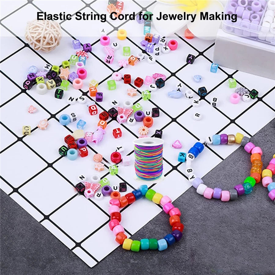 A collection of colorful elastic string cords and beads for jewelry making laid out on a grid.