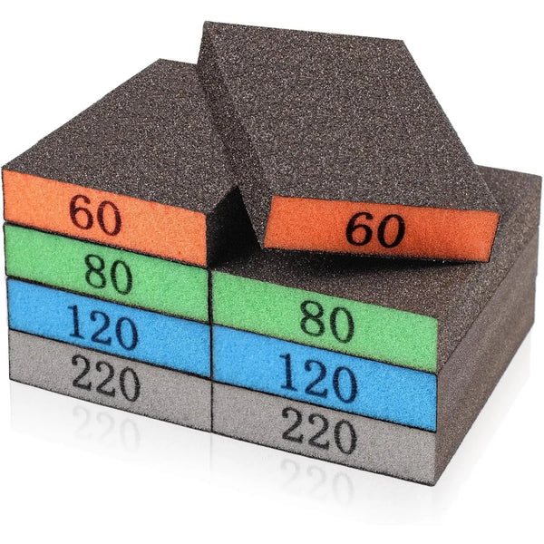 Assorted grit sanding sponge blocks in orange, green, blue, and gray stacked at an angle.