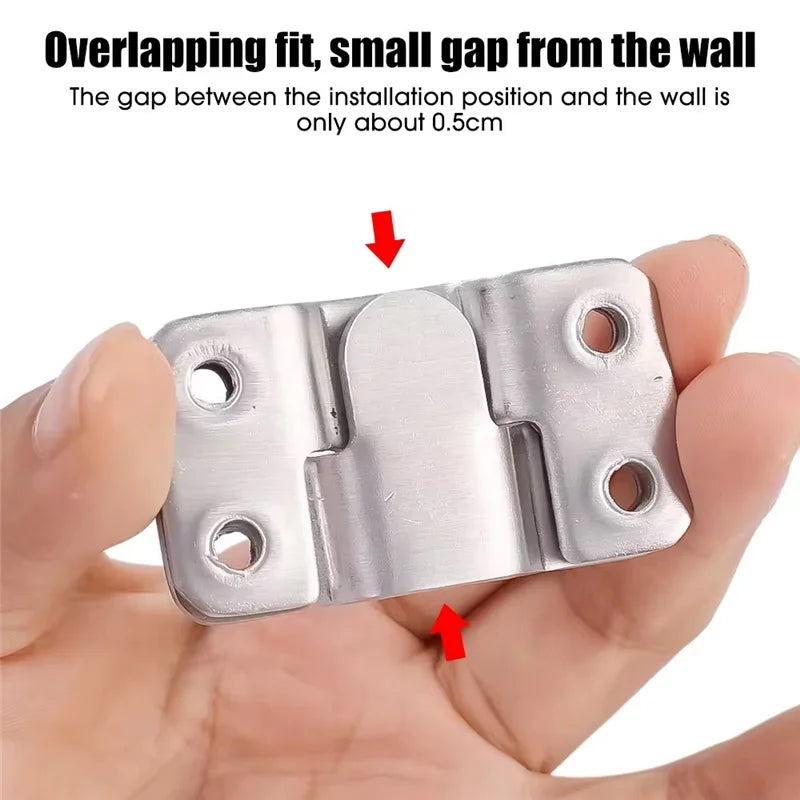 A hand holds a stainless steel hanging picture frame, showing the overlapping fit and small gap from the wall.