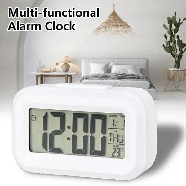 A white LED digital alarm clock displaying 12:00, set on a bedside table.