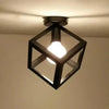 A black geometric chandelier lamp with a clear glass shade hangs from the ceiling.