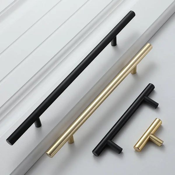 A set of modern brushed gold cabinet handles shown against a white panel.