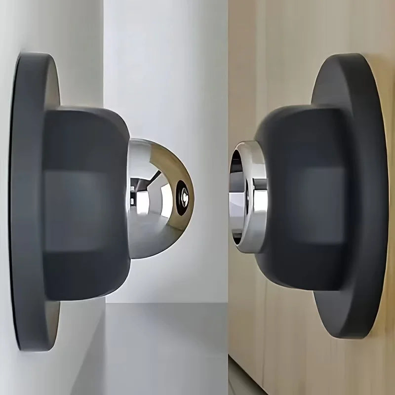 Gros plan d'un bloqueur de porte magnétique noir mat avec finition chrome poli, monté sur un mur clair.