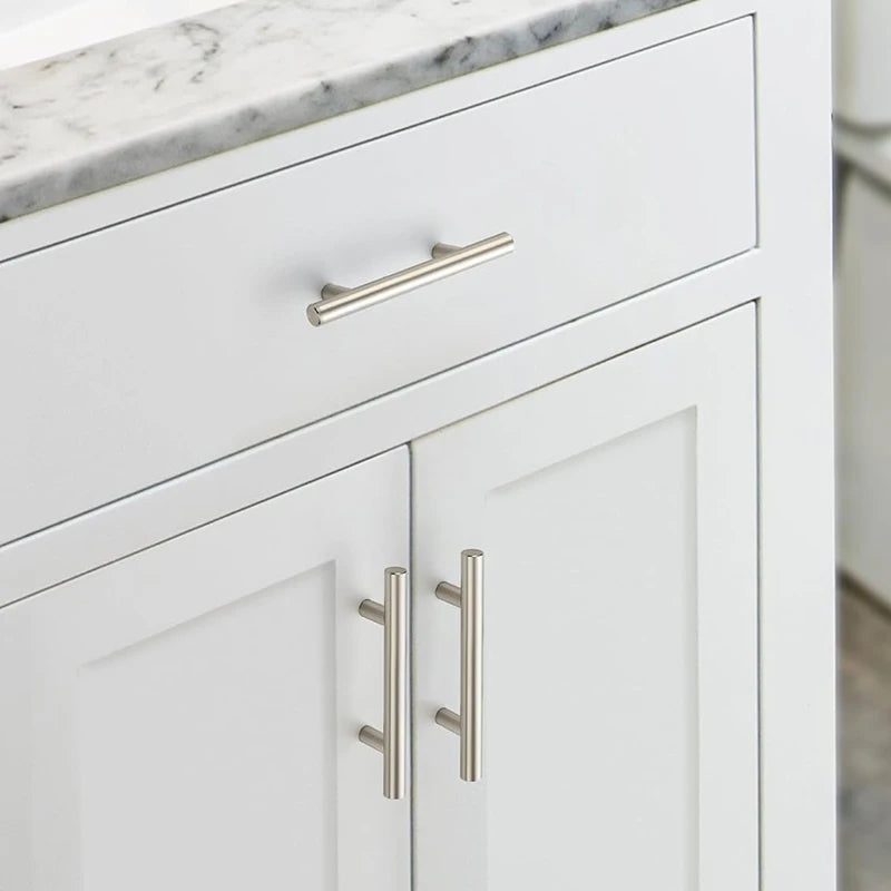 White cabinet drawer and door featuring brushed nickel and gold cabinet handles.