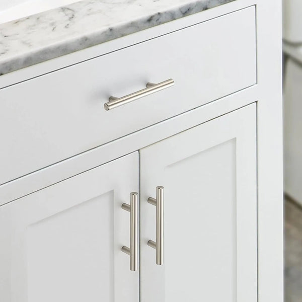 White cabinet drawer and door featuring brushed nickel and gold cabinet handles.