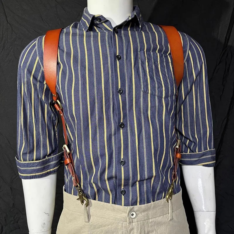 A man wearing a blue and yellow striped shirt with brown leather suspenders and light colored pants.