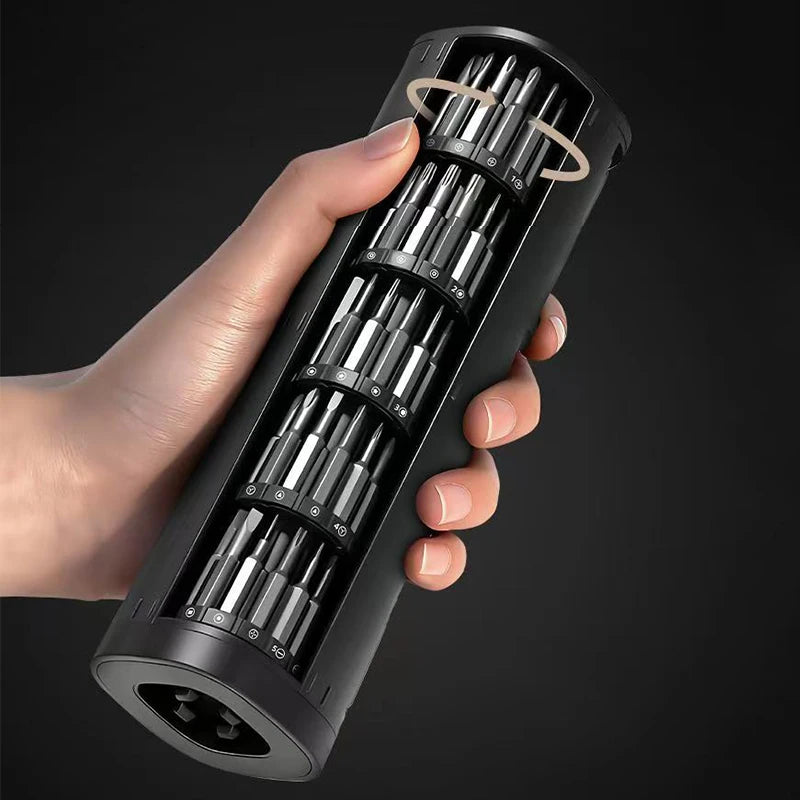 A hand holds a black electric precision screwdriver repair kit with multiple screwdriver bits inside.