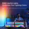 A man is sitting on a couch next to an RGB colorful floor lamp that illuminates the room.