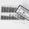 A plastic tray holds various stainless steel watch repair pins and spring bars with different diameters.