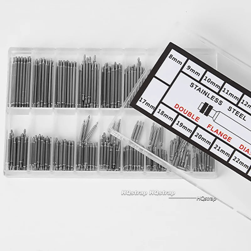 A plastic tray holds various stainless steel watch repair pins and spring bars with different diameters.