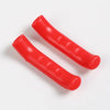 Two red silicone brake lever protector covers for bicycles lying on a white surface.