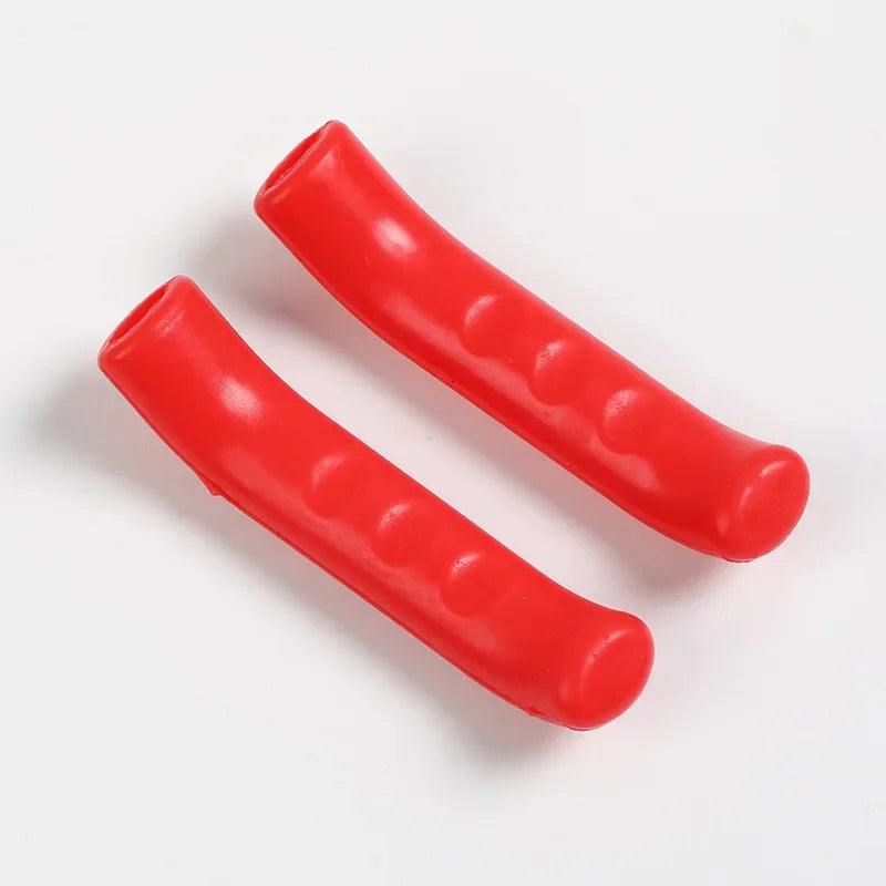 Two red silicone brake lever protector covers for bicycles lying on a white surface.