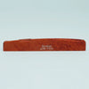 A wooden guitar bone bridge saddle with the name Guyker ATR-7231 engraved on it.