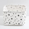 A white linen storage basket with a star pattern is shown on a white surface.