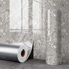 Roll of silver marble wall decals against a gray marbled bathroom or kitchen wall.