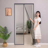 A young woman stands next to a modern glass door screen in a room, demonstrating the magnetic door screens for mosquito and f