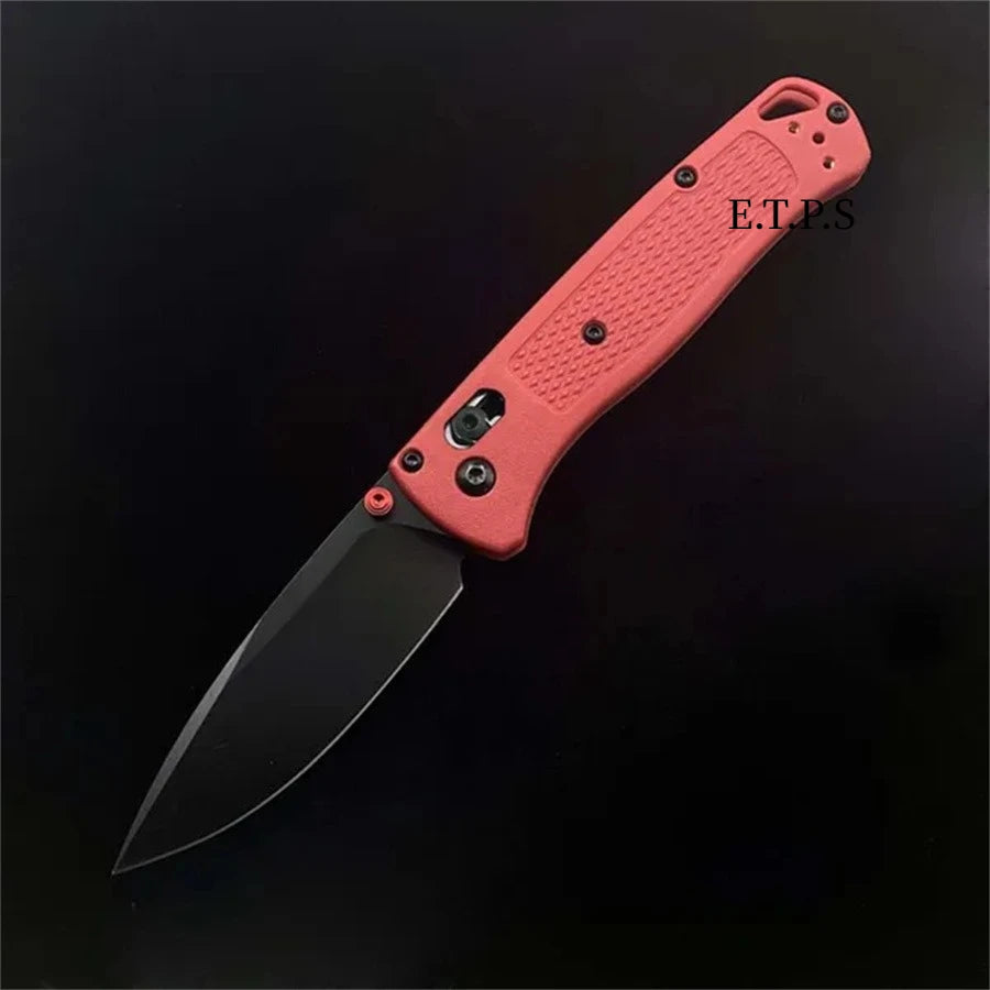 Un couteau de poche pliable orange avec lame noire et poignée rose contre un fond sombre.