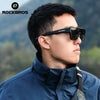 A man wearing black ROCKBROS polarized sunglasses outdoors while wearing a blue jacket.