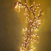 A branch of LED cherry blossom tree lights illuminates a textured yellow wall.