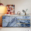 A modern kitchen cabinet featuring blue marble with gold veining and a light countertop.