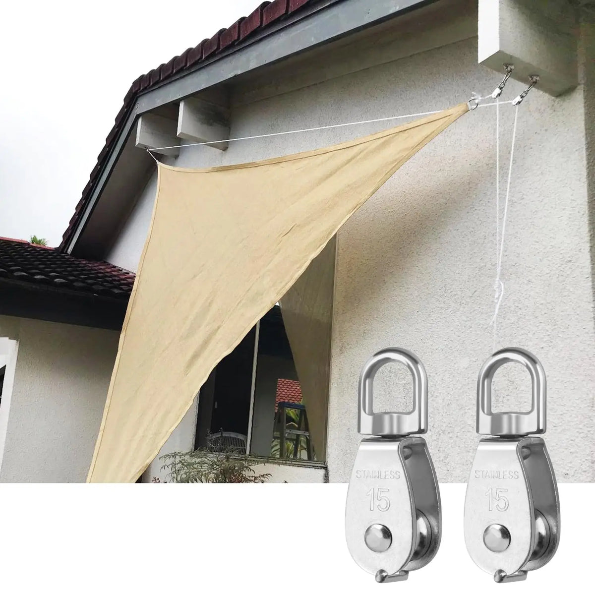 Stainless steel wire rope pulley block suspended from a building facade by a beige fabric canopy