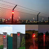 Outdoor security alarm featuring solar infrared motion sensors mounted on a fence line at dusk.