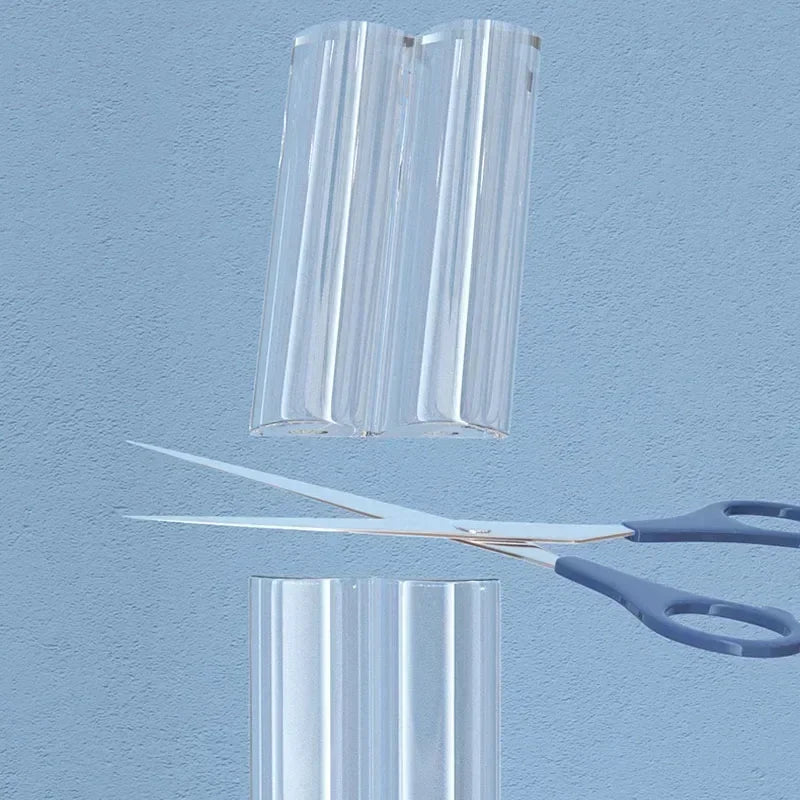Two clear plastic safety edge guards are shown against a light blue background, with a pair of scissors below them.