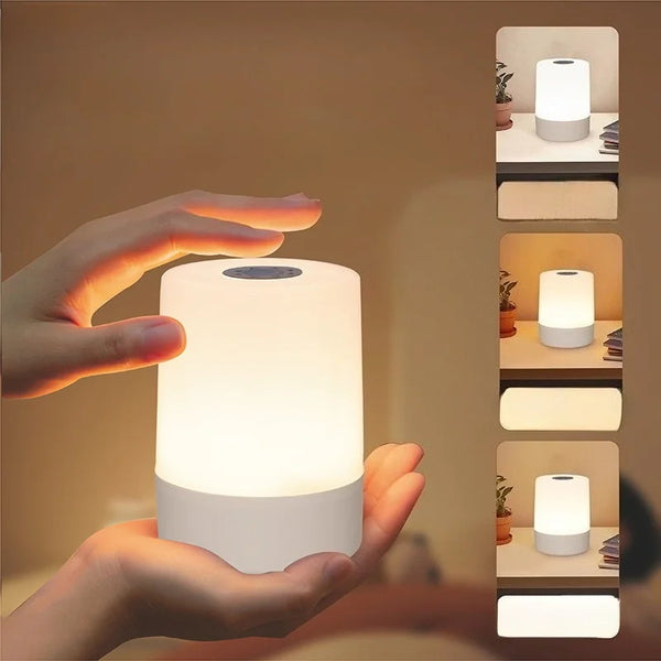 A hand is holding a white, modern LED desk lamp with a glowing light, demonstrating its use for reading or nighttime illumina