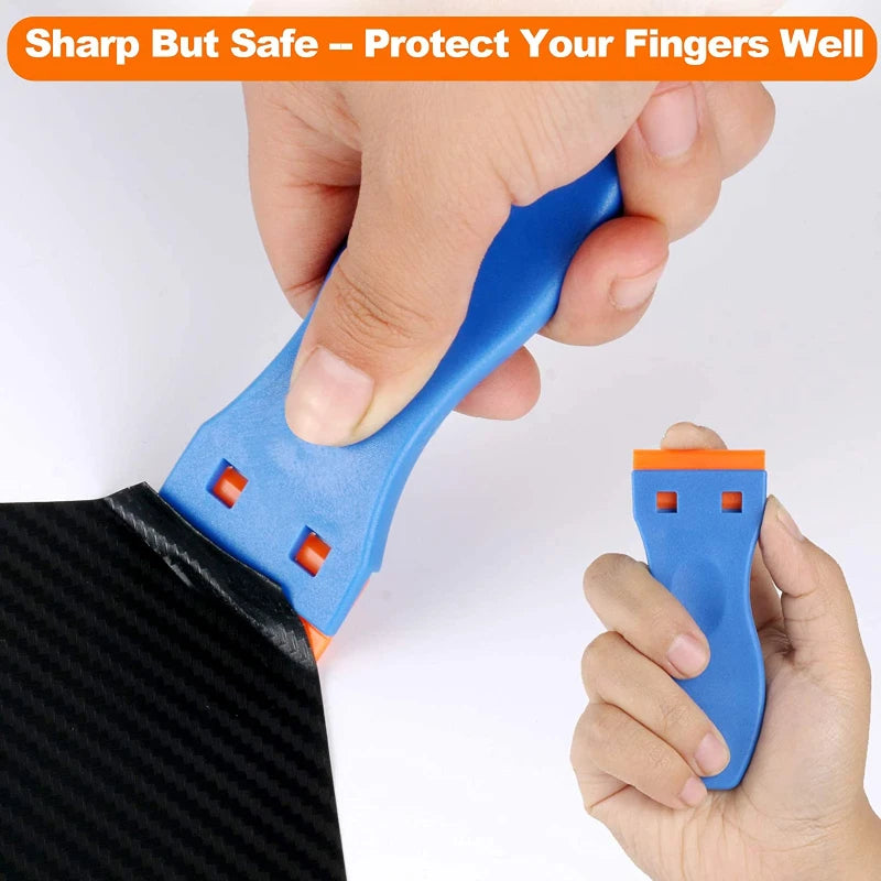 A hand is using a blue multi-tool scraper with plastic blades to remove residue from a black surface.