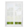 White pleated window blinds covering a window with a view of green trees and grass