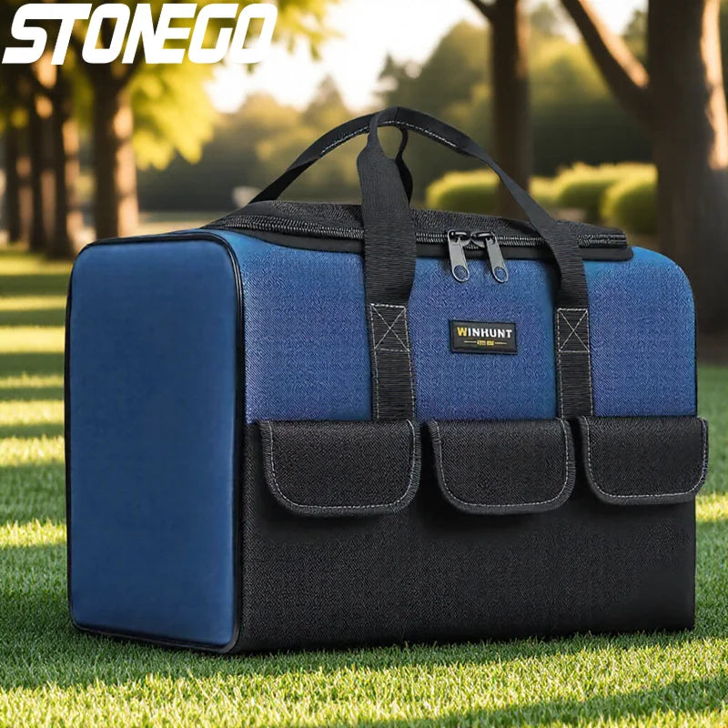 A blue and black heavy duty multi-compartment tool organizer bag resting on green grass.