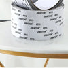Roll of white Jimator window screen repair tape resting on a gold-rimmed table.