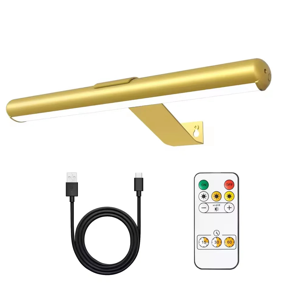 A gold wall mounted LED picture light fixture shown with its power cord and remote control.