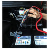 A hand holds a digital automotive voltage tester, showing its tip near an electronic device.