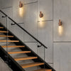 Interior moderno con escalera negra de madera y luces LED montadas en la pared.