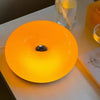 Helle orange LED-Wandleuchte in Donutform auf weißem Tisch