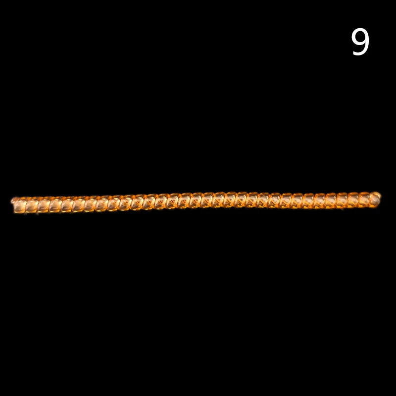 A small, elongated, golden-brown object used for ring sizing adjustment.
