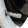 Close-up of a car tire pressure monitoring valve with a silver fitting and colored internal components.